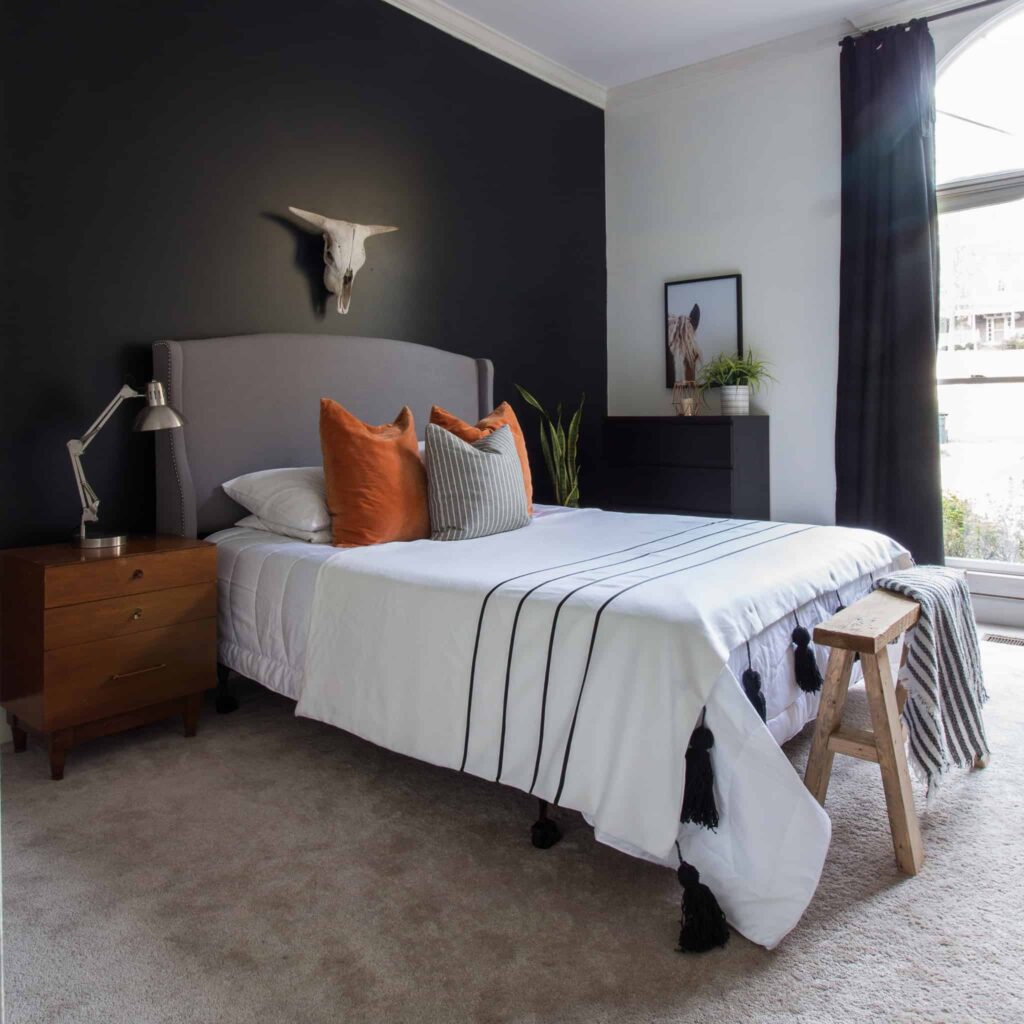 A notebook and measuring tape on a bed, symbolizing the planning phase of a DIY bedroom makeover