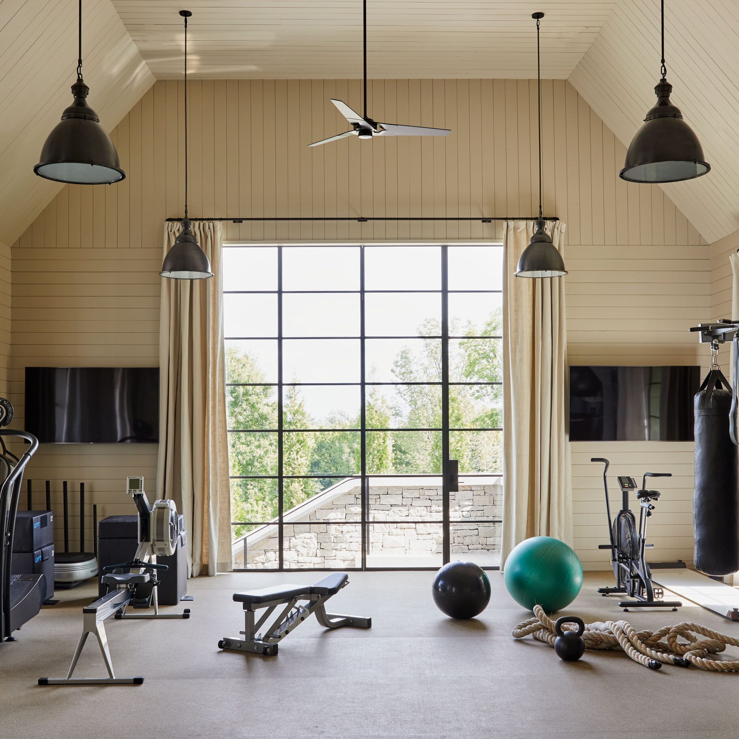 Sustainable gym design utilizing natural light, eco-friendly flooring, and potted plants.