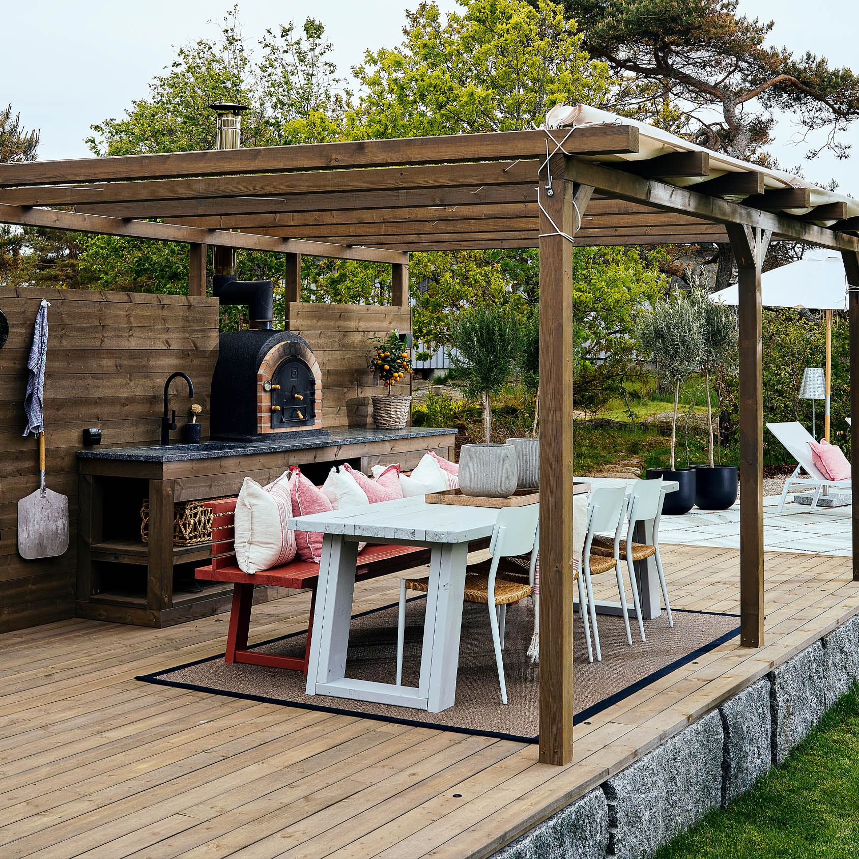 Affordable panoramic patio with weatherproof furniture, an umbrella, and potted plants.